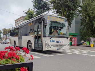 Autobus na ulicy Łaskiej. Przed nim widać kwiaty.